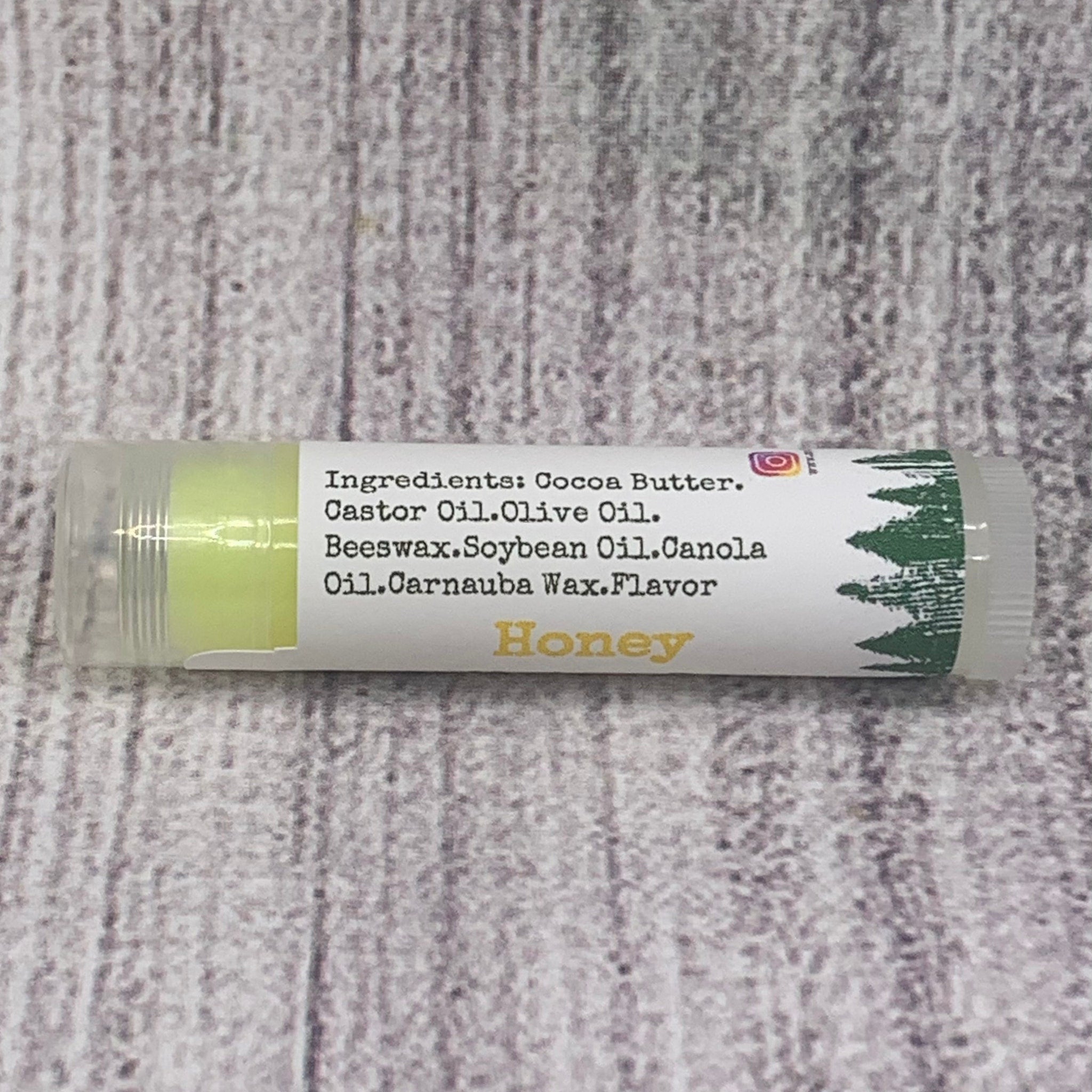 Lip balm tube with yellow balm, white label, and "Honey" text