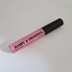 Lip gloss tube with pink gloss, black cap, and Ivory & Obsidian Cosmetics text