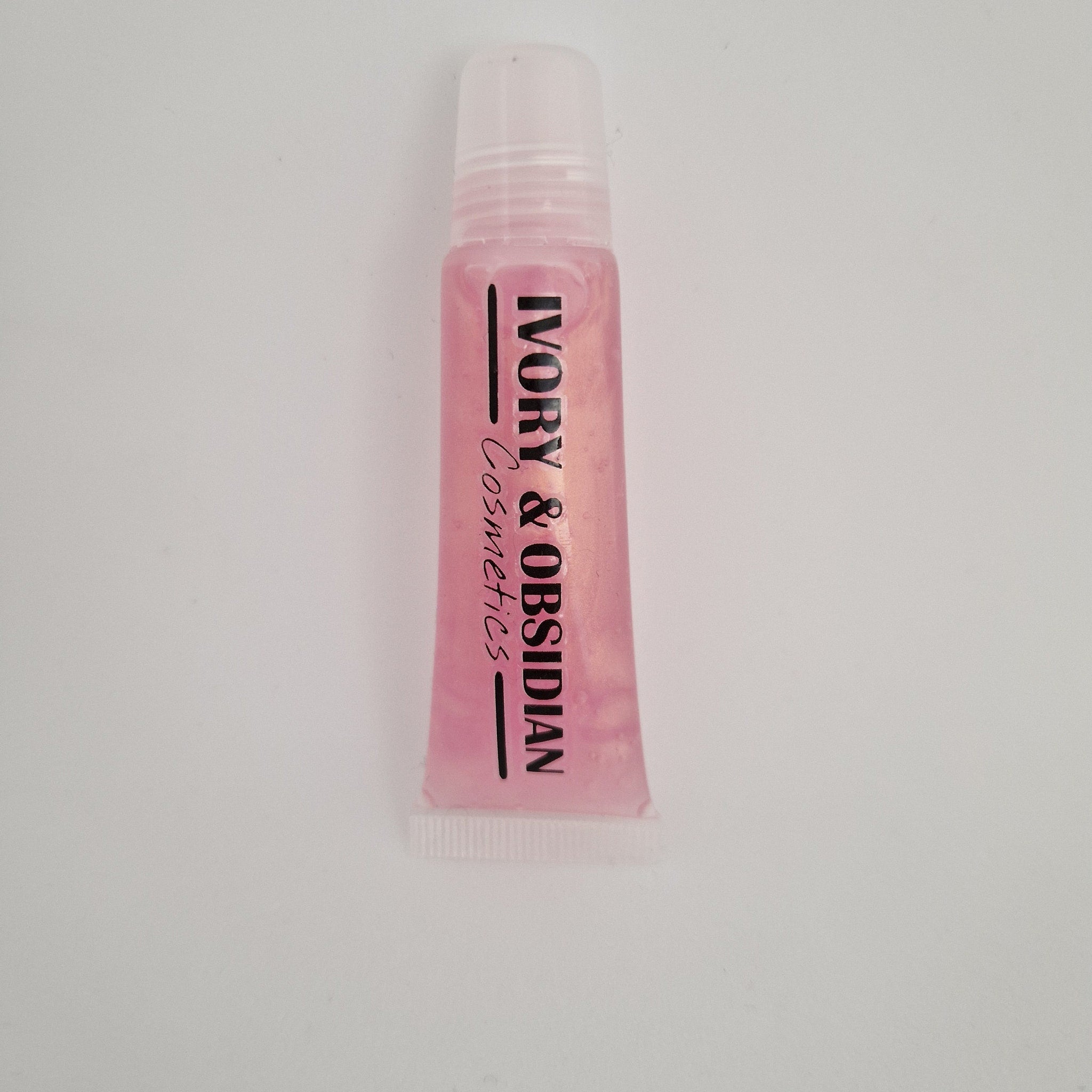 Lip gloss tube with pink liquid, white cap, and Ivory & Obsidian Cosmetics text
