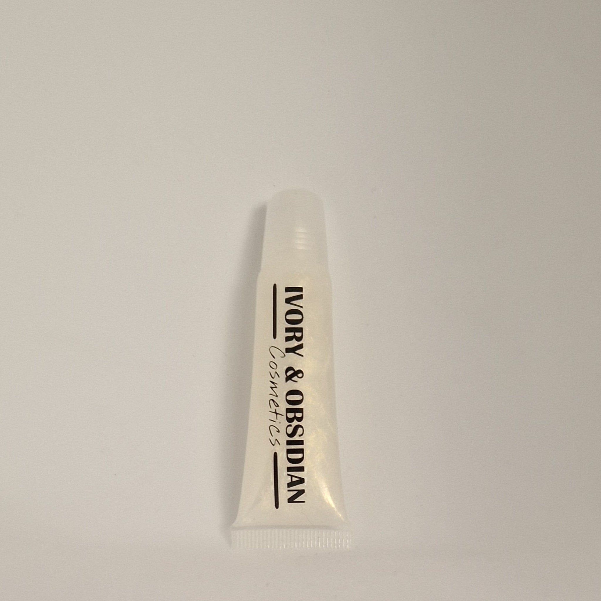 Lip gloss tube with clear, glossy finish and Ivory & Obsidian Cosmetics text on white background