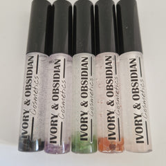 Lip gloss tubes with black caps, clear tubes, and IVORY & OBSIDIAN Cosmetics text visible