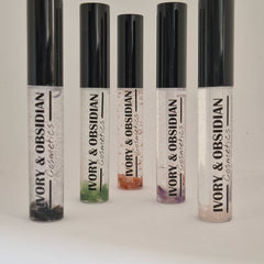 Lip gloss tubes with black caps, clear tubes, and IVORY & OBSIDIAN Cosmetics text visible