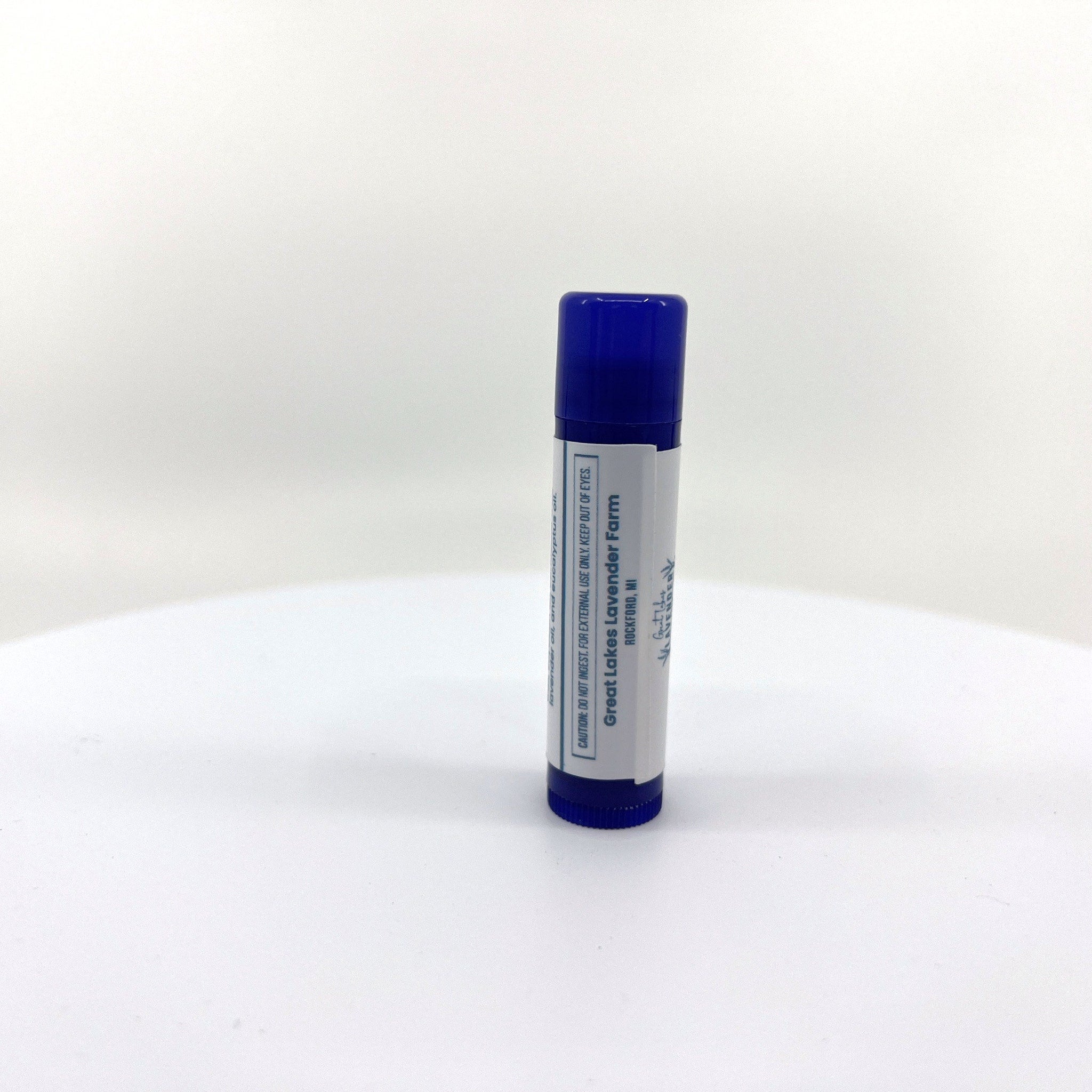 Lip balm tube with blue cap and white label, Great Lakes Lavender Farm text visible