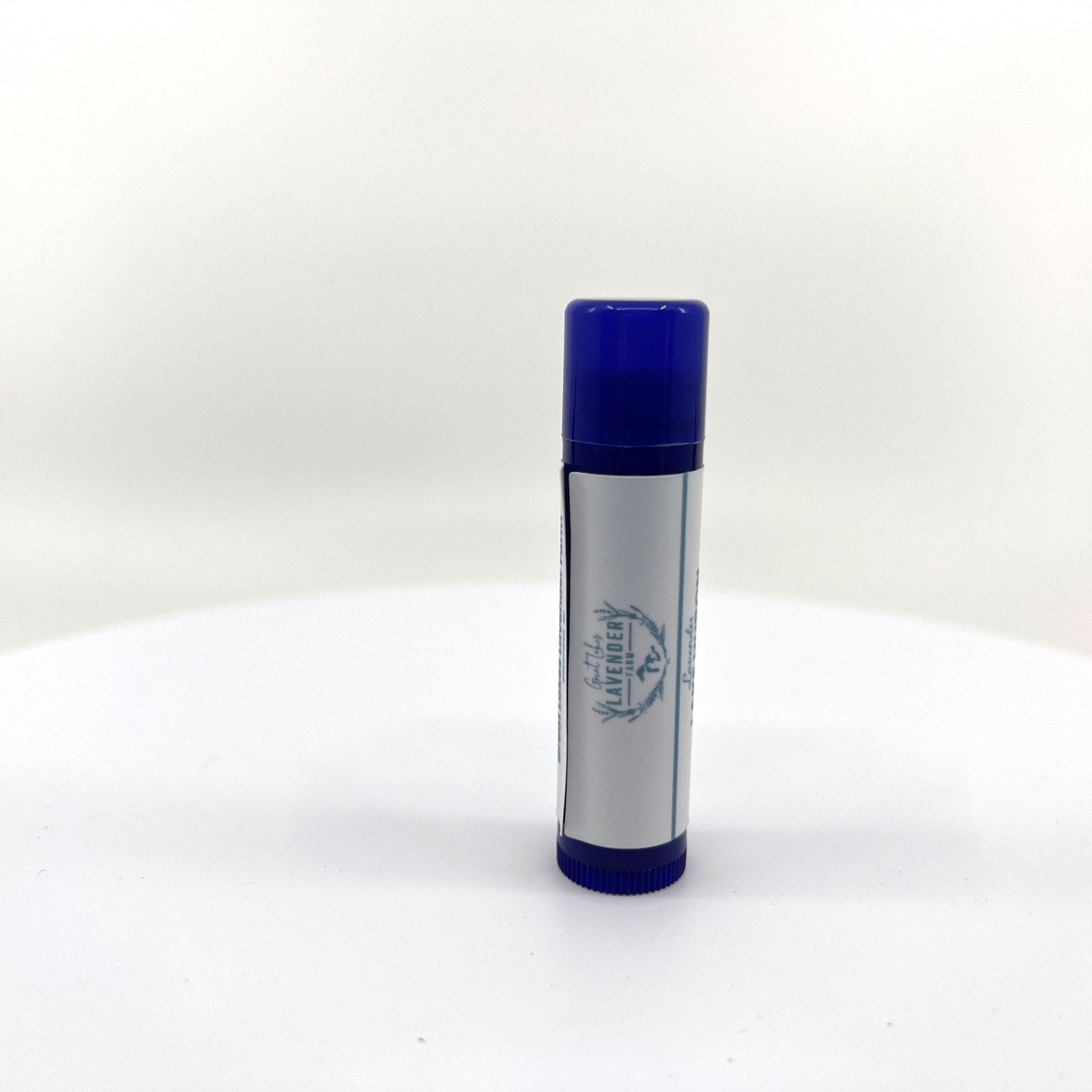 Lip balm tube with blue cap and label, Great Lakes Lavender Farm text visible on white background