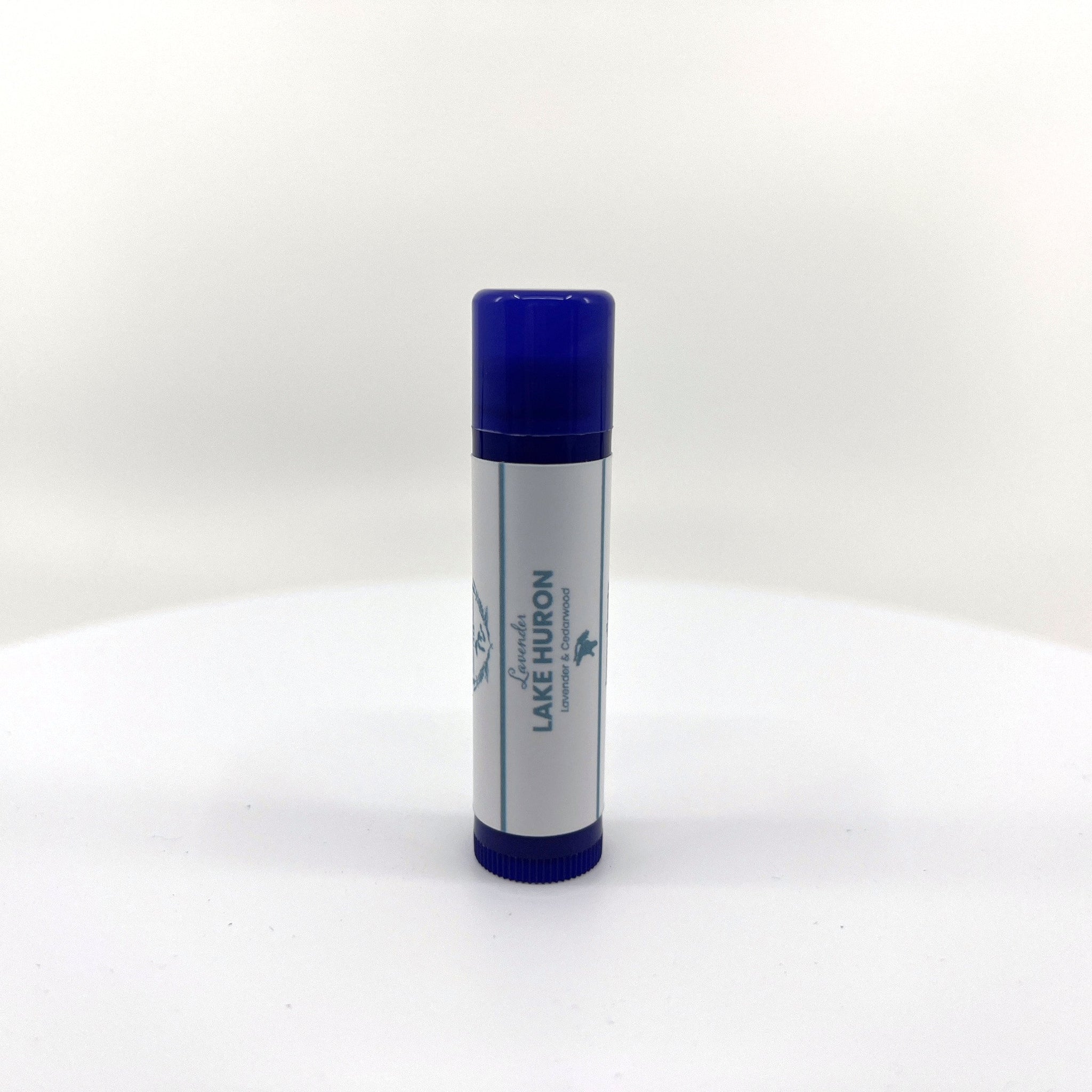 Lip balm tube with blue cap and base, white label with text, product packaging