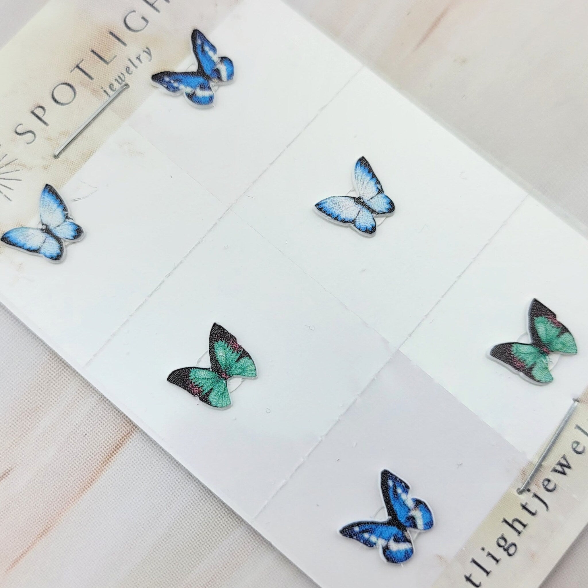 Side view of white glitter butterfly eyeshadow stickers showing adhesive backing and wing details