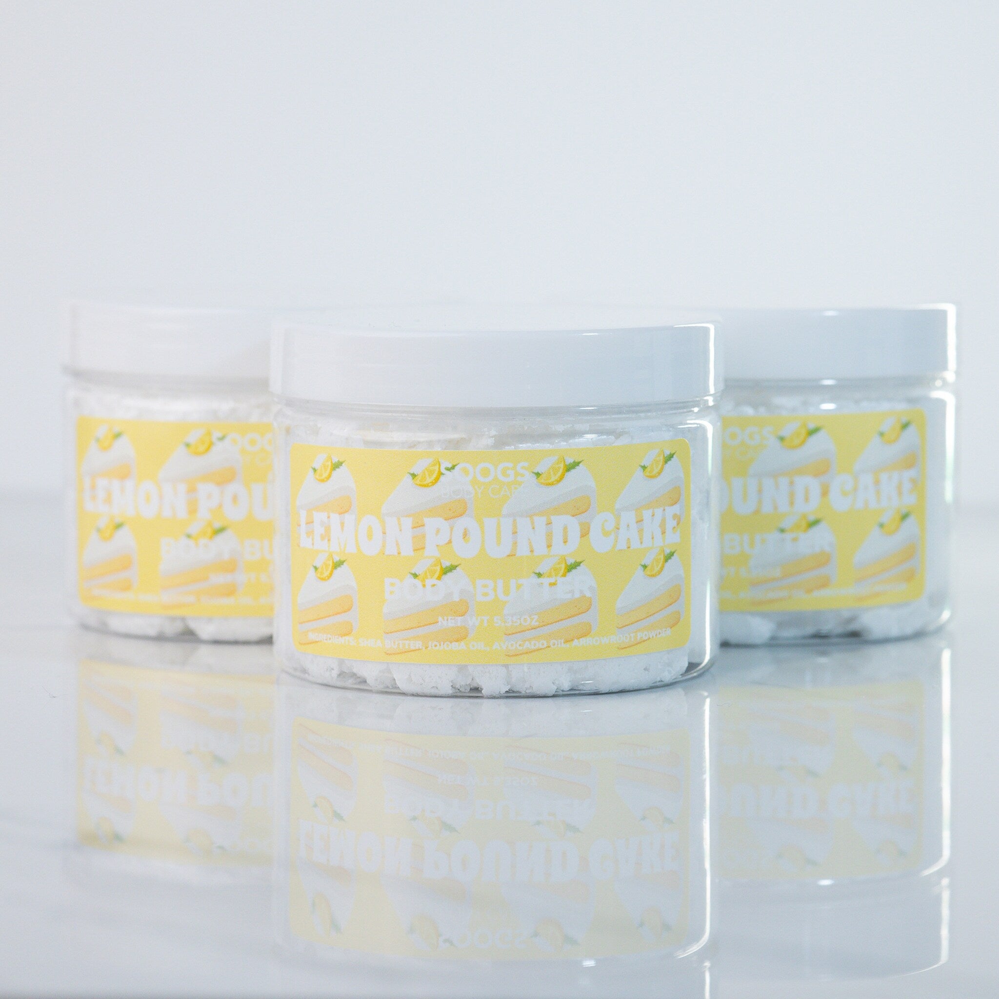 Body butter jars, clear plastic, white lids, yellow label with Soogs Body Care text