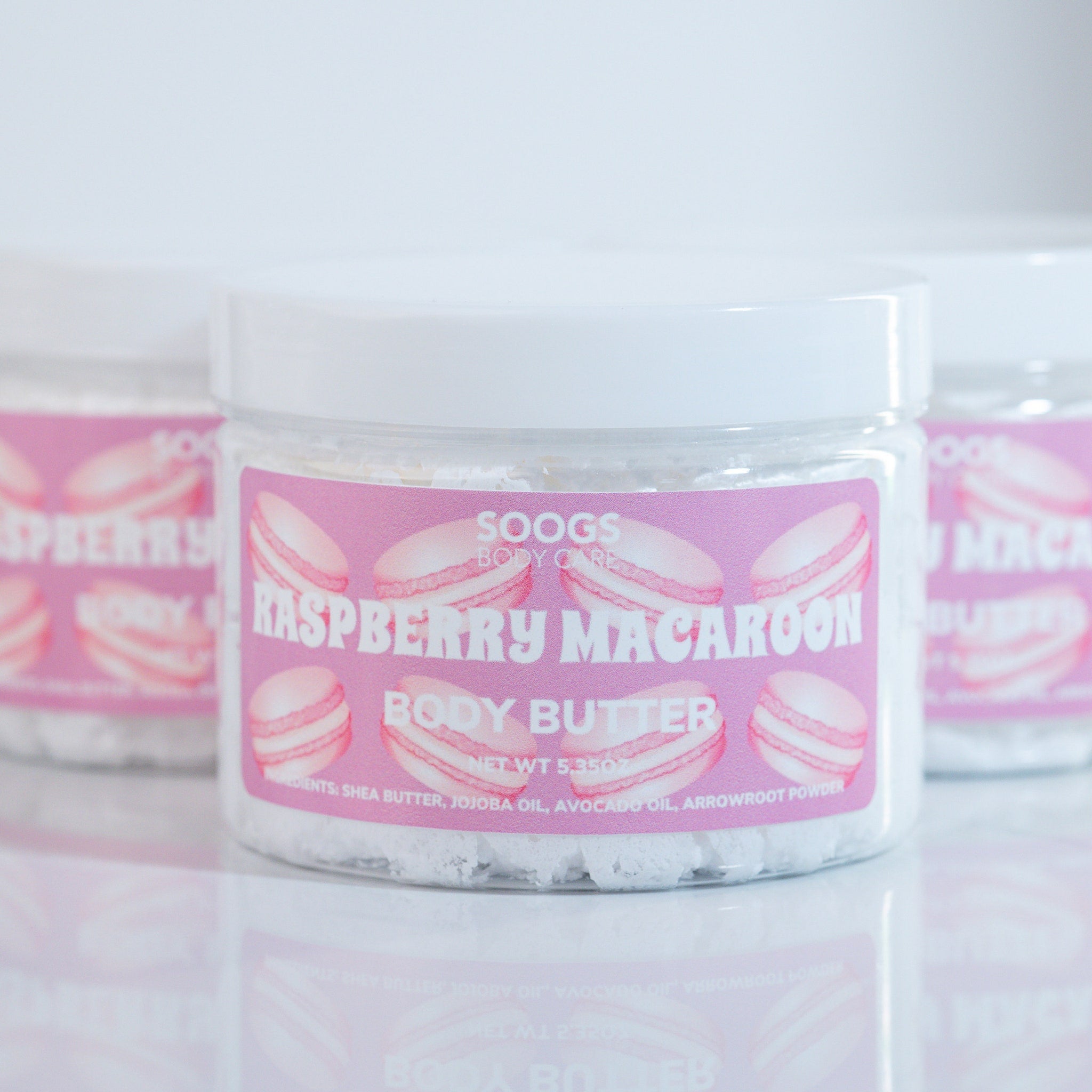 Body butter jar with pink label, white container, and "Soogs Body Care" text visible