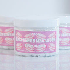 Body butter jar with pink label, white container, and "Soogs Body Care" text visible