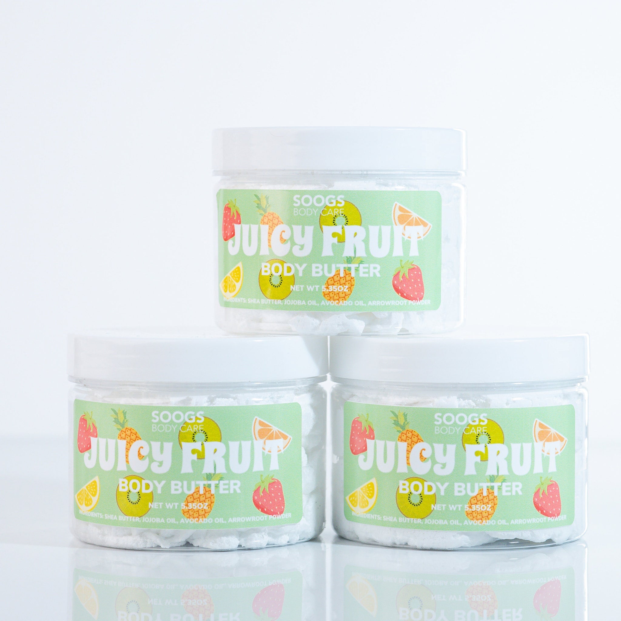 Body butter jars with white lids, green labels, and fruit illustrations, Soogs Body Care brand
