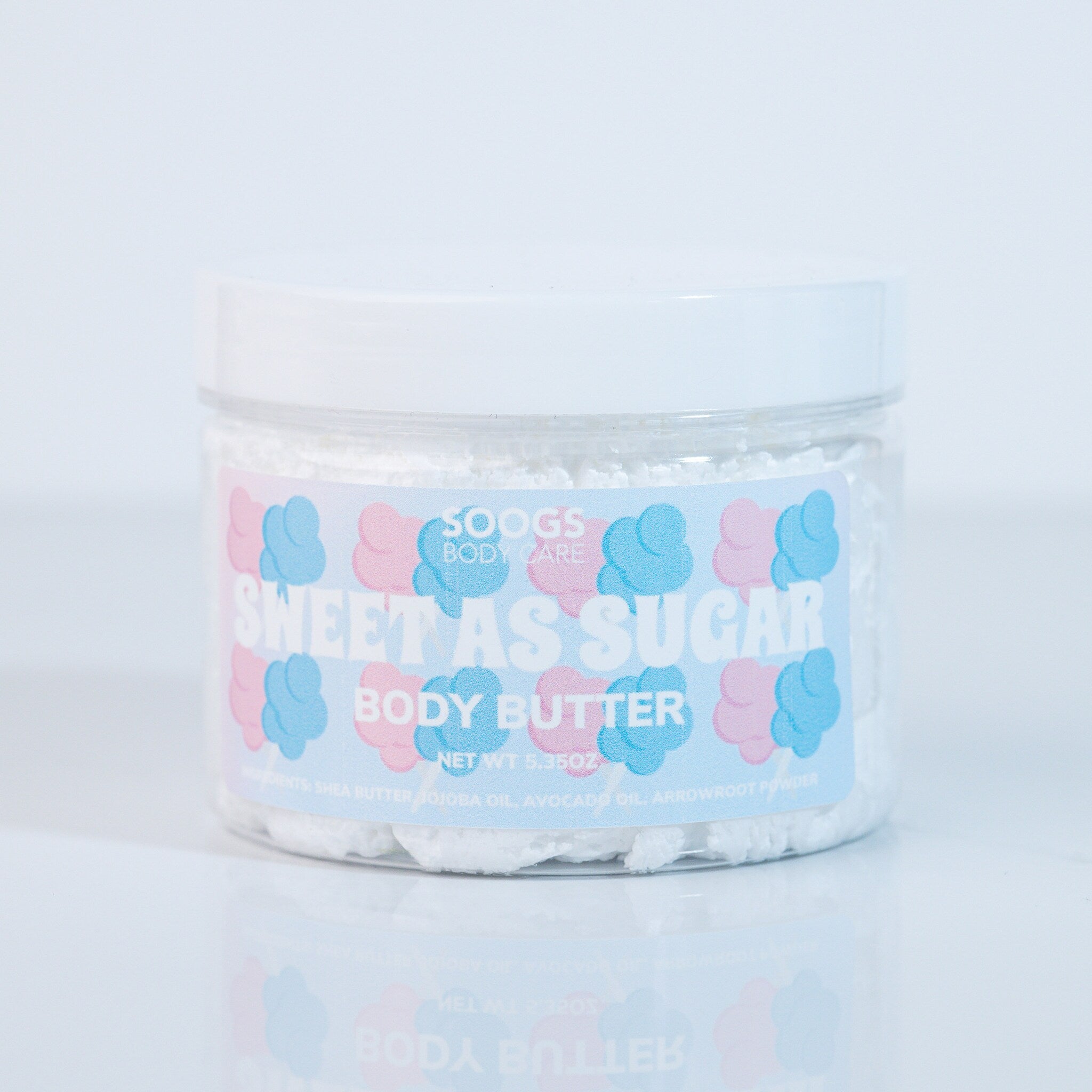 Body butter jar with white contents, clear plastic container, and Soogs Body Care label