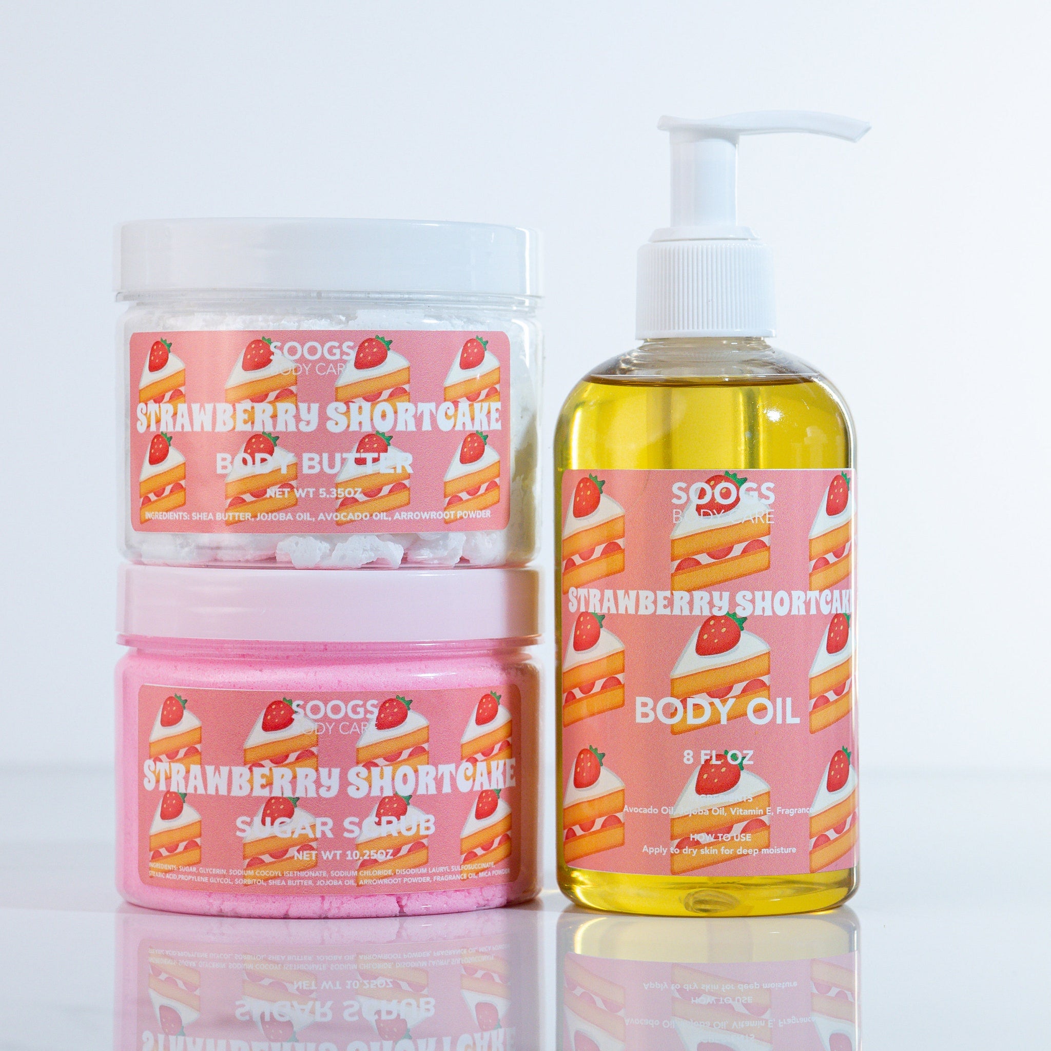Body care products with SOOGS branding, pink and clear jars, and a strawberry shortcake design.
