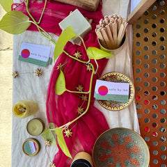 Business cards with sola by Isa branding, red and white background, gold star garland, and decorative plates