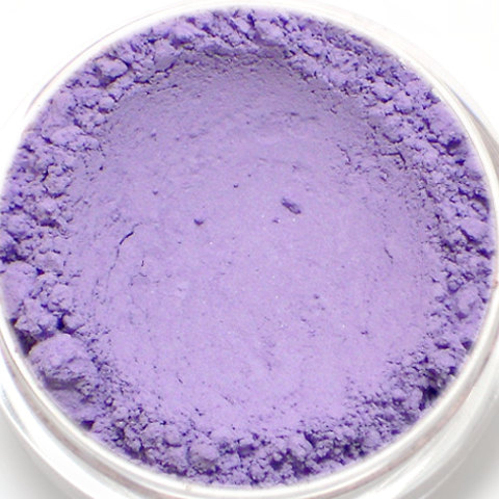 Side view of lavender matte eyeshadow pan in sleek black compact with product name 'Meadow' visible