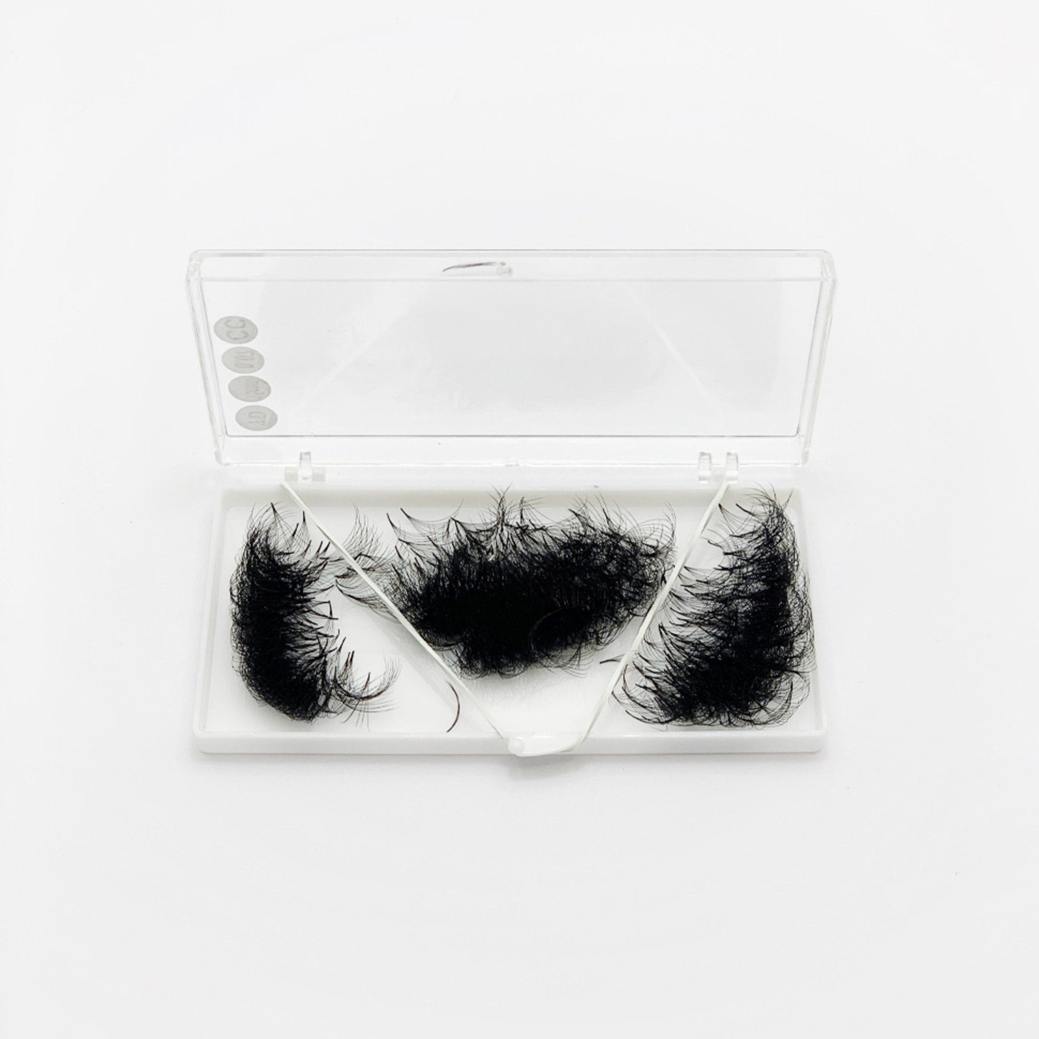 False eyelashes in black synthetic fibers, white case with clear lid, cosmetic product