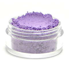 Close-up of lavender matte eyeshadow being applied to eyelid with a fluffy brush