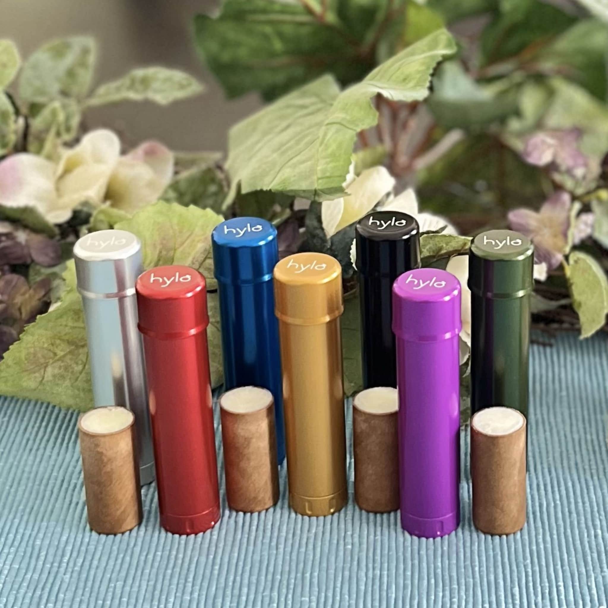 Lip balm tubes in various colors with "hyla" text on top, with matching cardboard balm cylinders