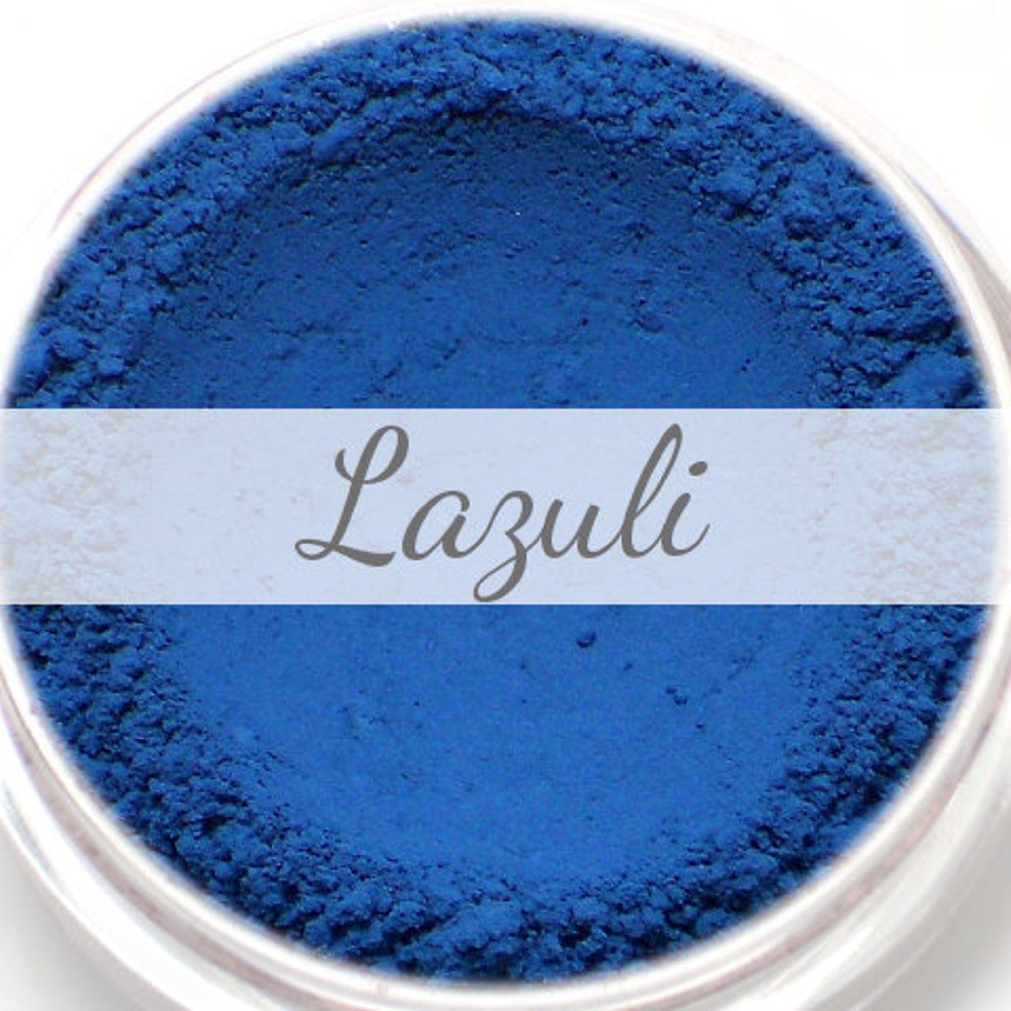 Eyeshadow sample, matte blue powder, "Lazuli" text on white band, in clear container
