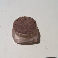 Close-up of matte dark brown loose mineral eyeshadow powder with rich pigmentation in a vegan formula
