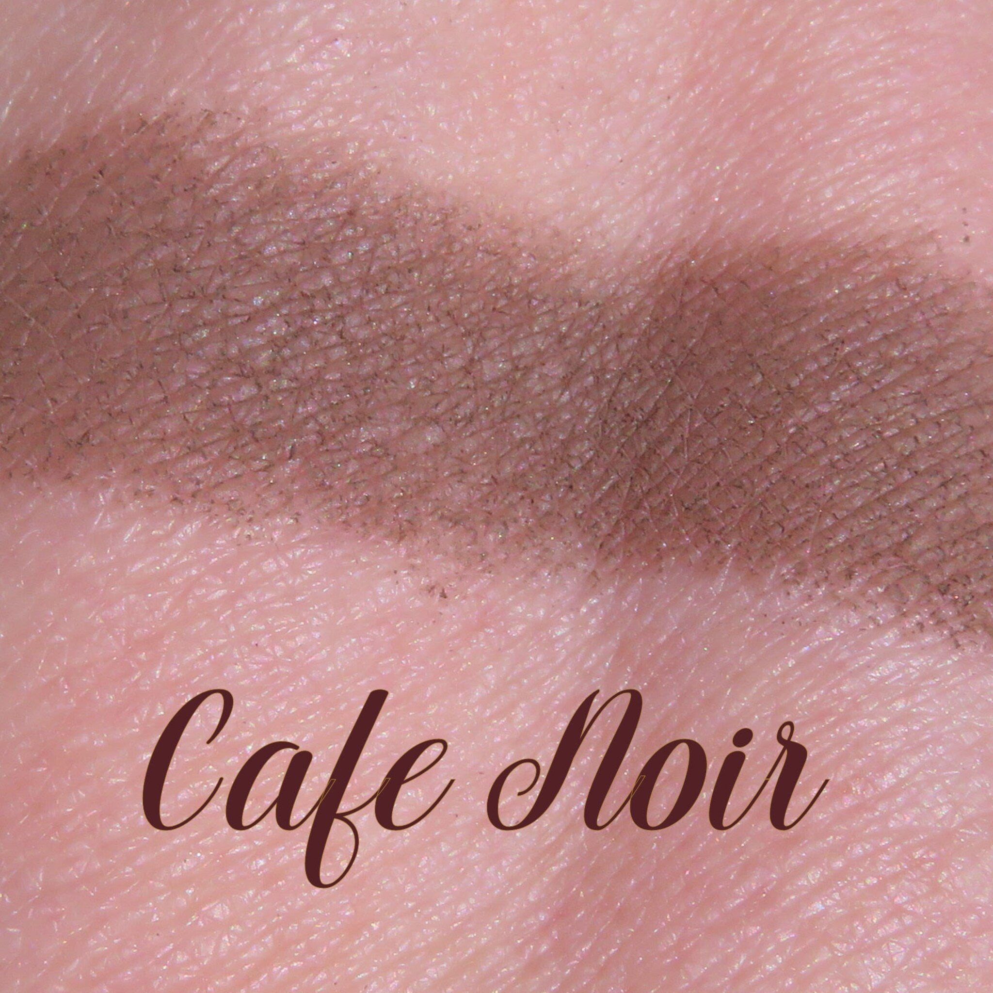 Side view of matte dark brown loose mineral eyeshadow powder spilling from jar onto surface