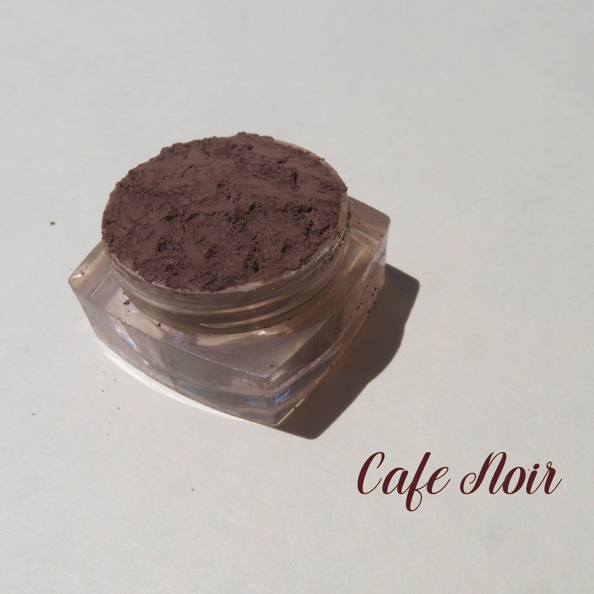 Matte dark brown mineral eyeshadow in loose powder form with vegan Cafe Noir pigment, cruelty-free, shown in open jar
