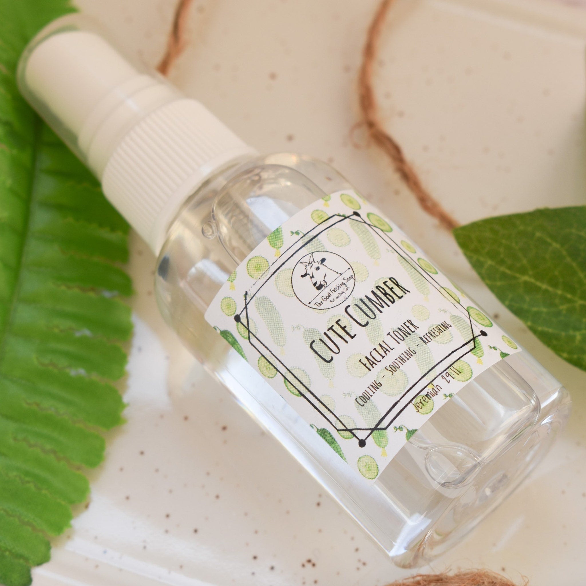 Facial toner bottle clear plastic with white cap and Cute Cucumber label on white surface