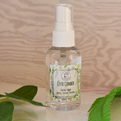 Facial toner bottle with clear liquid, white pump, and "Cute Cumber" label with cucumber design