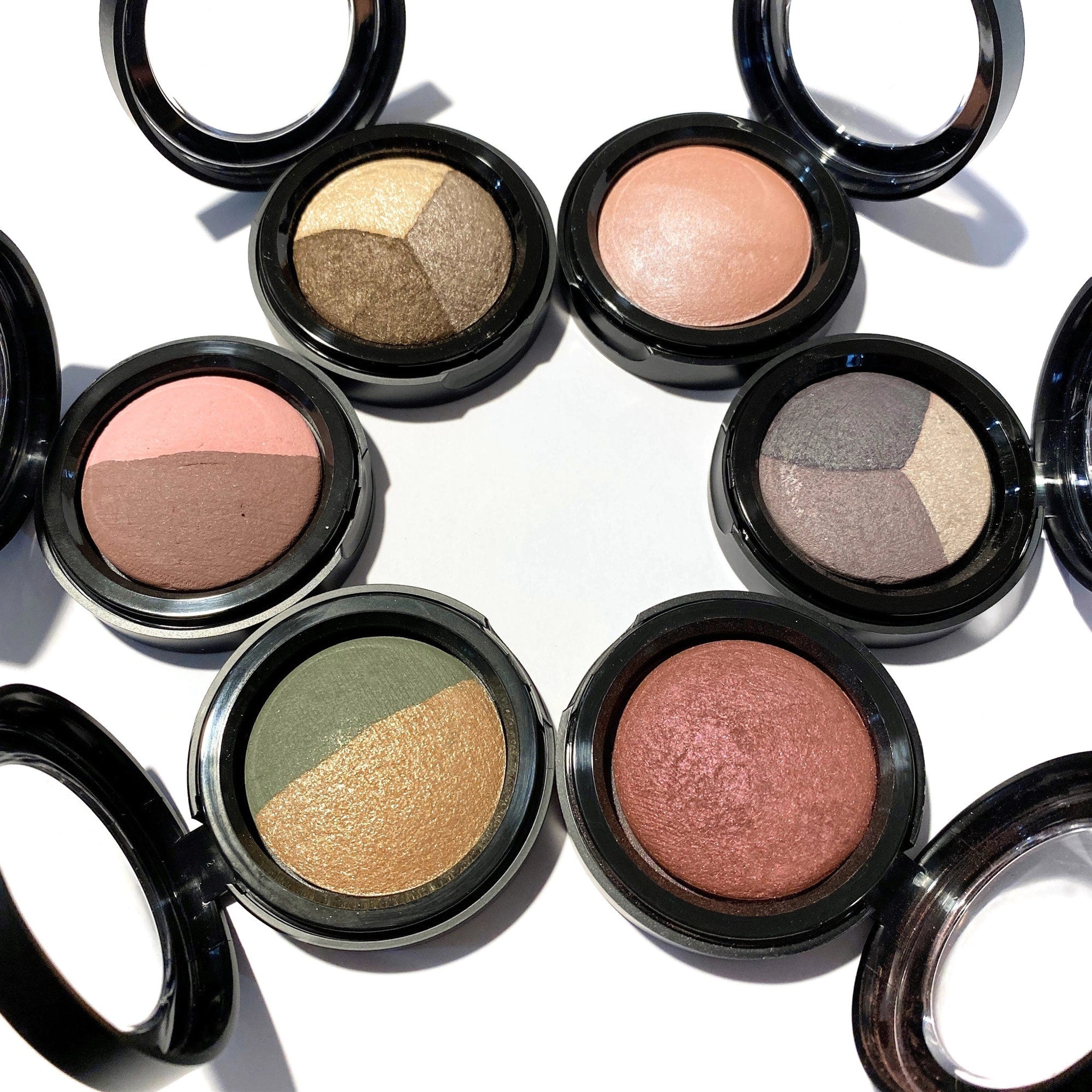 Hand applying warm vanilla baked eyeshadow with a fluffy brush for a soft, natural look