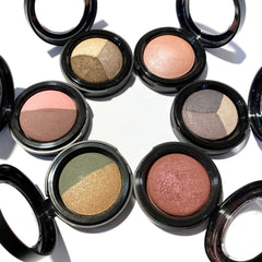 Hand applying warm vanilla baked eyeshadow with a fluffy brush for a soft, natural look