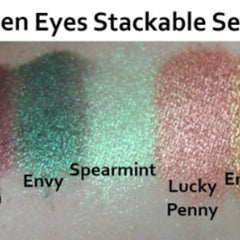 Hand applying emerald green eyeshadow with a blending brush, showcasing rich pigment on eyelid