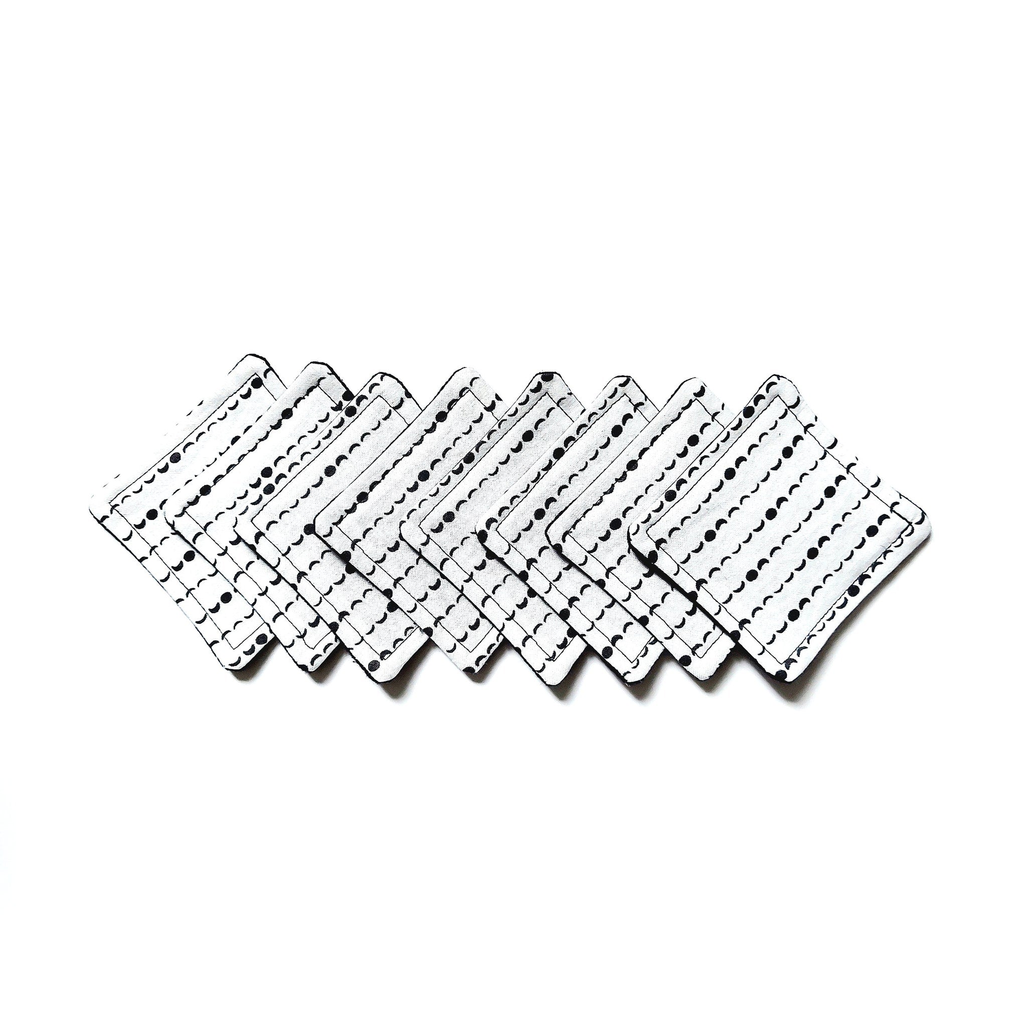 Coasters white with black pattern, square shaped, stacked on white background