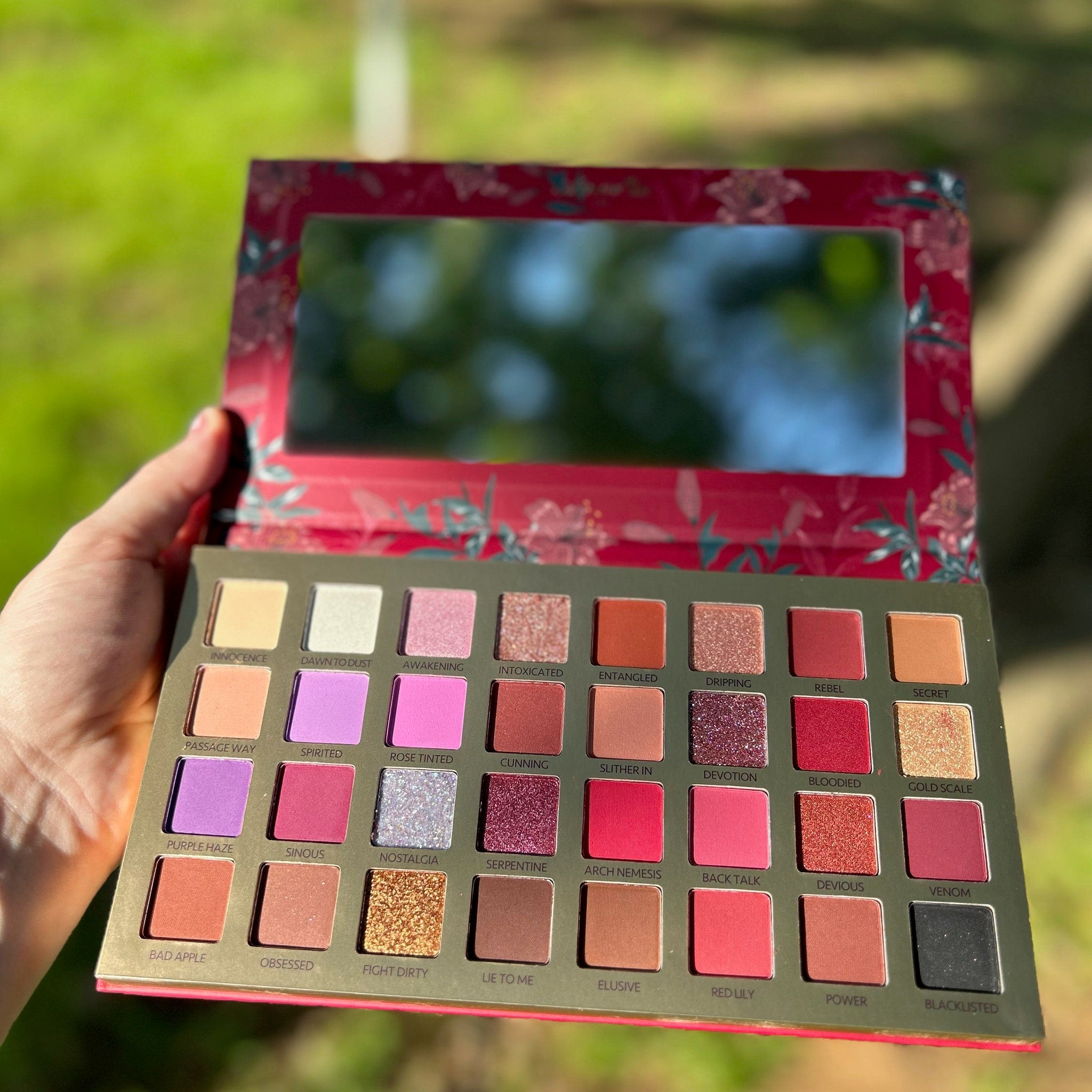 Close-up of Pigmented Bad Blood Eyeshadow pan showing rich crimson powder texture and shimmer finish