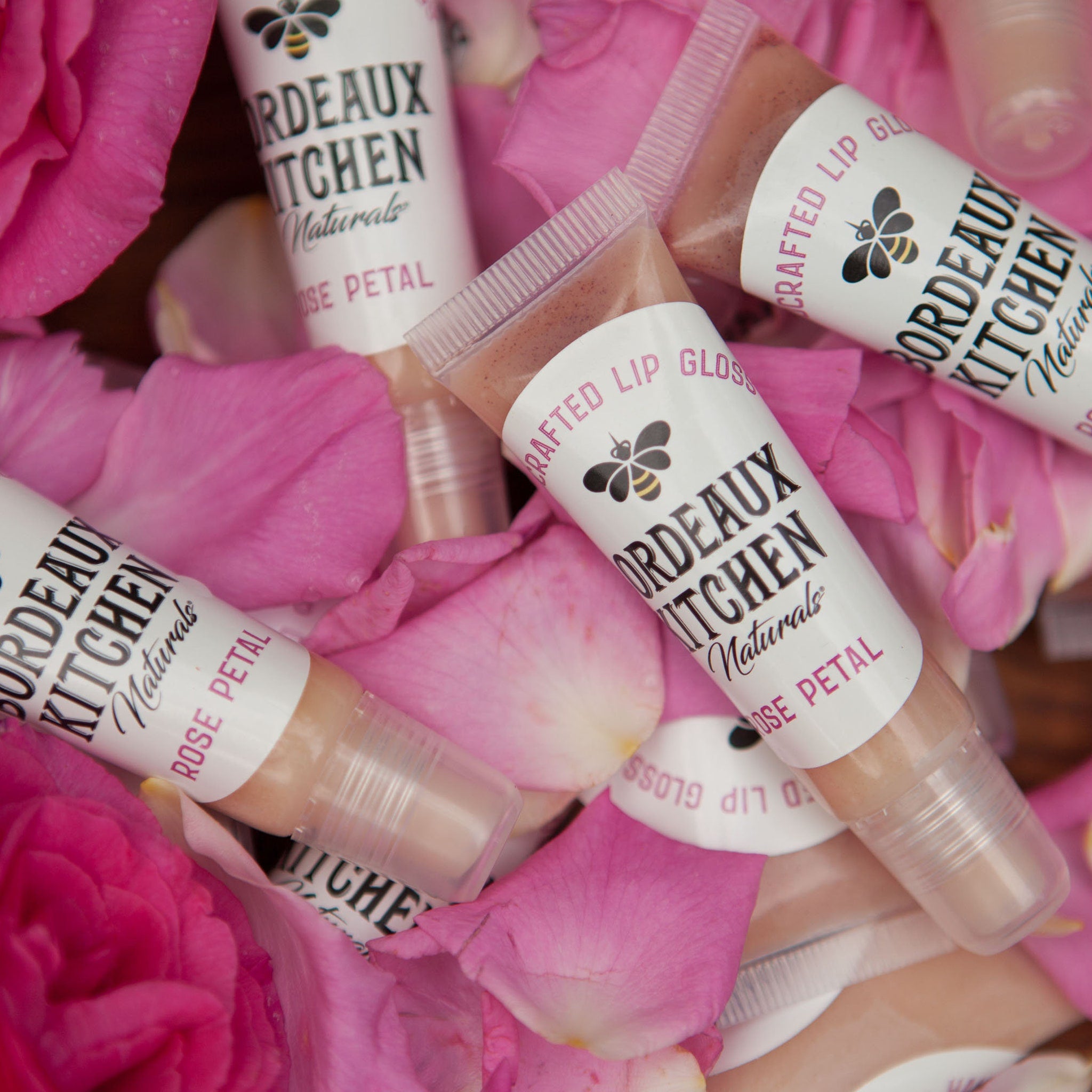 Lip gloss tubes with clear plastic, light brown color, and "Bordeaux Kitchen Naturals" text on white labels
