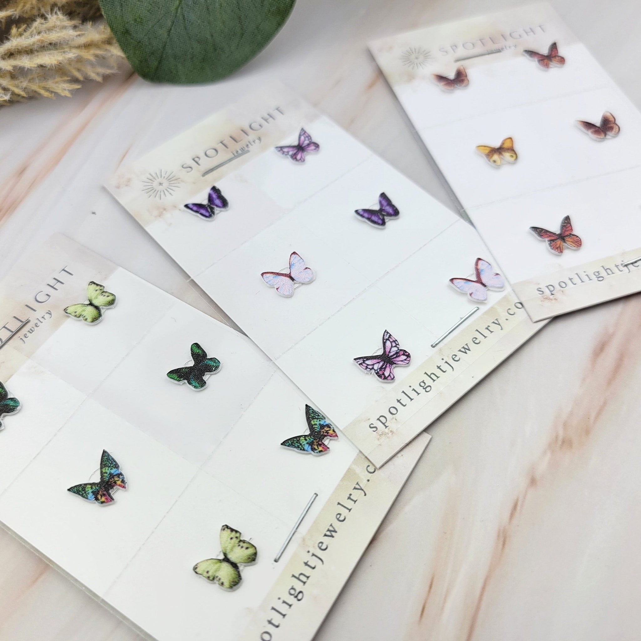 Close-up detail of white glitter butterfly eyeshadow decals showing intricate wing patterns and adhesive backing