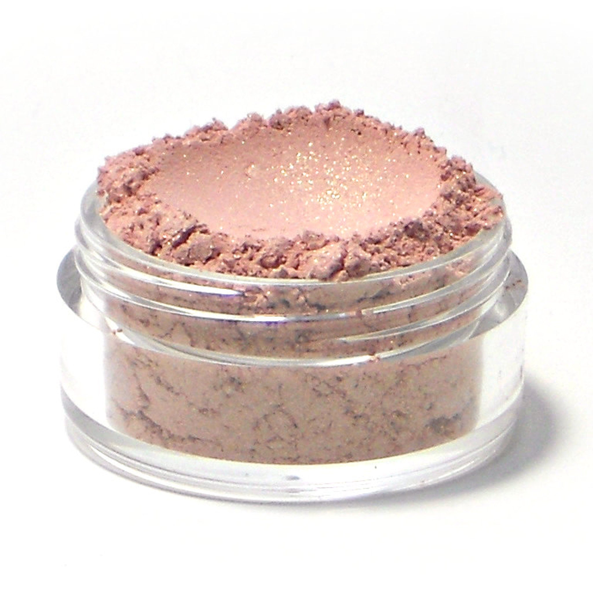 Close-up of light golden pink vegan mineral eyeshadow with soft shimmer in compact pan