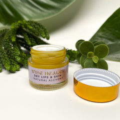 Lip balm jar with yellow liquid, gold lid, and "Wise Healer" label visible