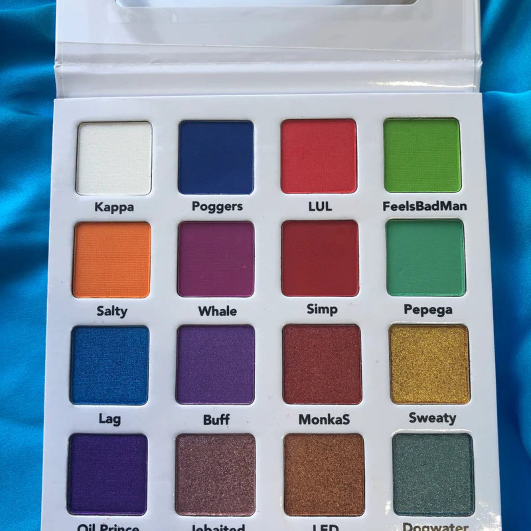 Close-up of vibrant pink and blue anime-inspired eye shadows with shimmer finish in sleek black palette