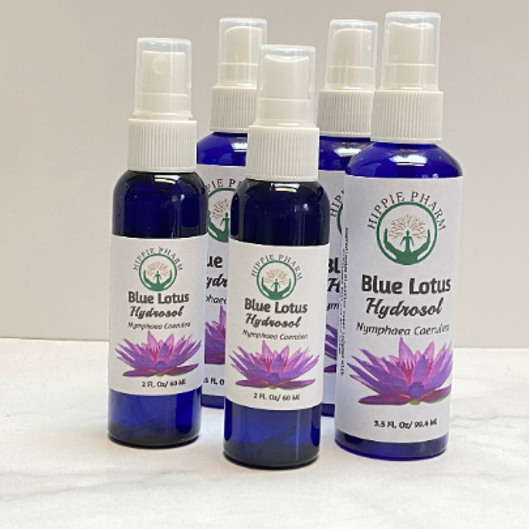 Blue Lotus Hydrosol bottles, dark blue glass, white labels, Hippie Pharm branding visible