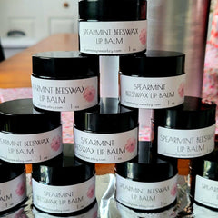 Spearmint beeswax lip balm in black jars with white labels, charmebynee.etsy.com text visible
