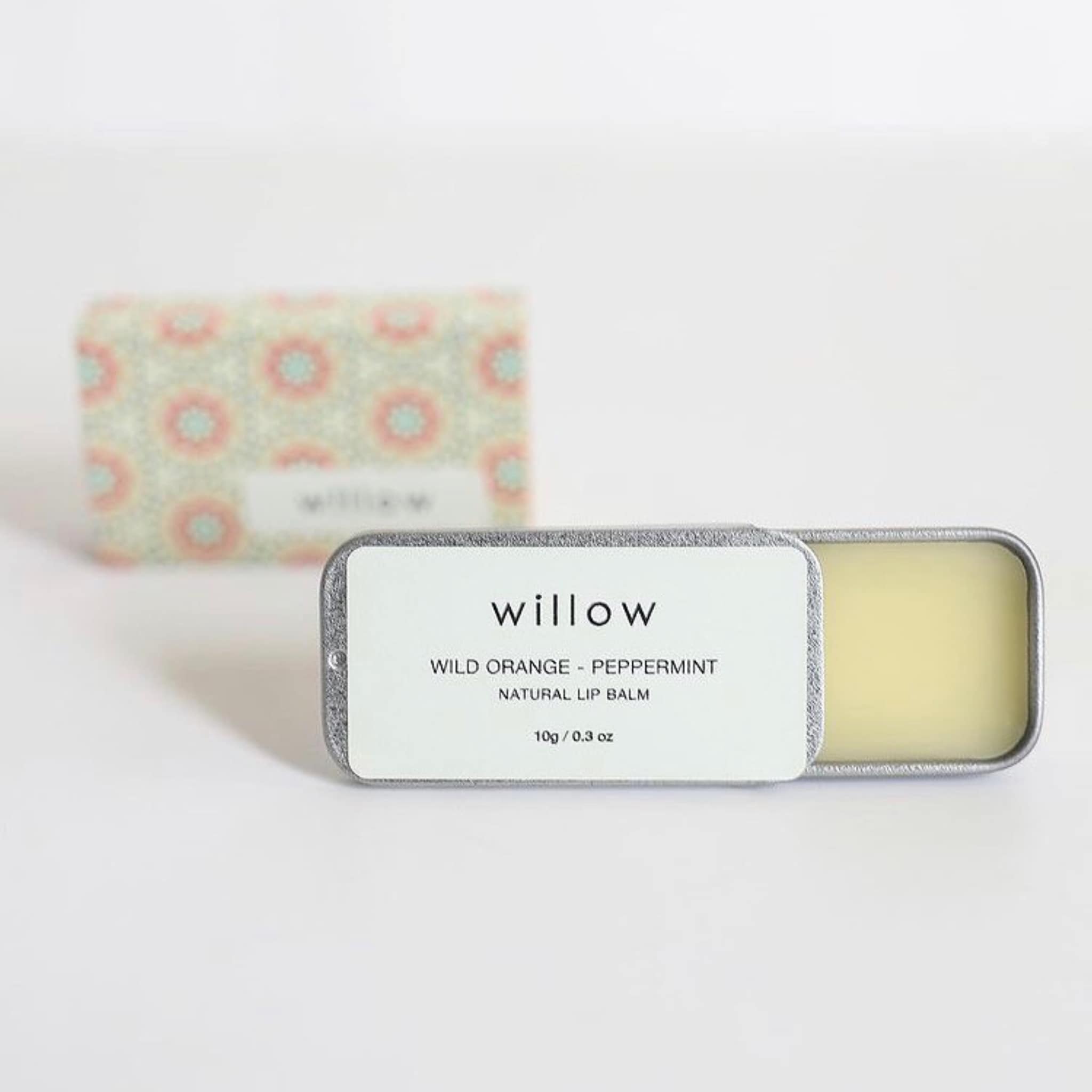 Lip balm tin with silver metal, white label with "willow" text, and yellow balm inside