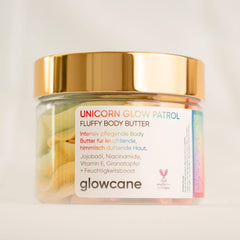 Close-up of pastel pink unicorn glow body butter with whipped fluffy texture in a sleek white jar