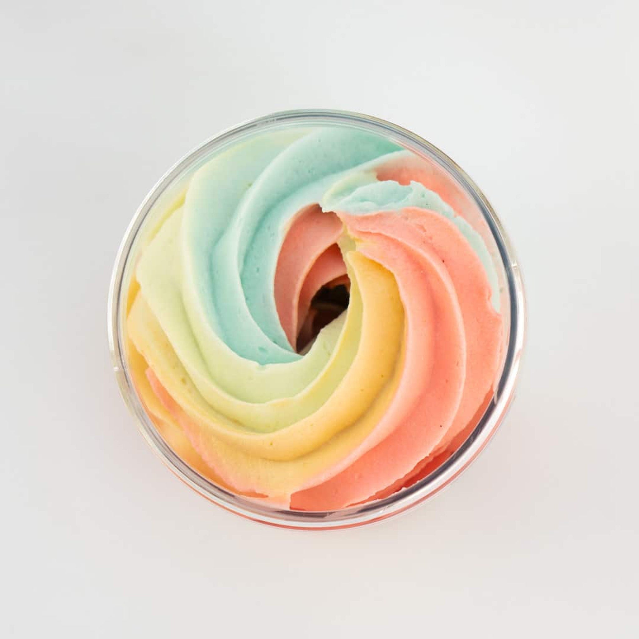 Pastel pink jar of unicorn glow body butter with gold lid and fluffy whipped texture, sitting on marble surface
