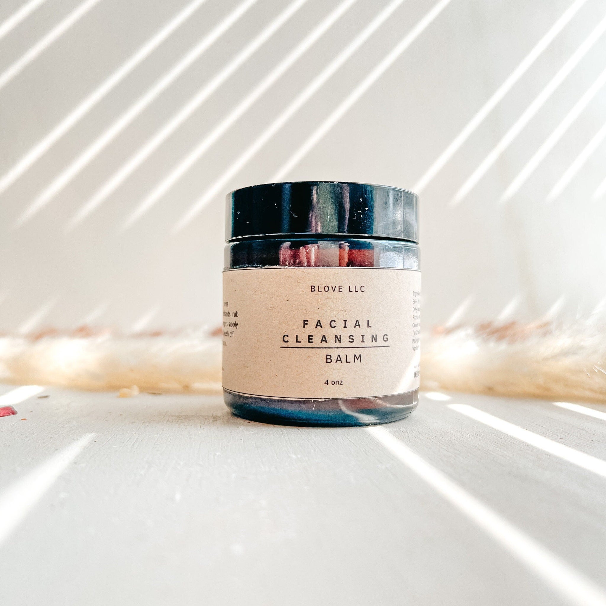 Facial cleansing balm in a glass jar with a black lid and a paper label, BLOVE LLC