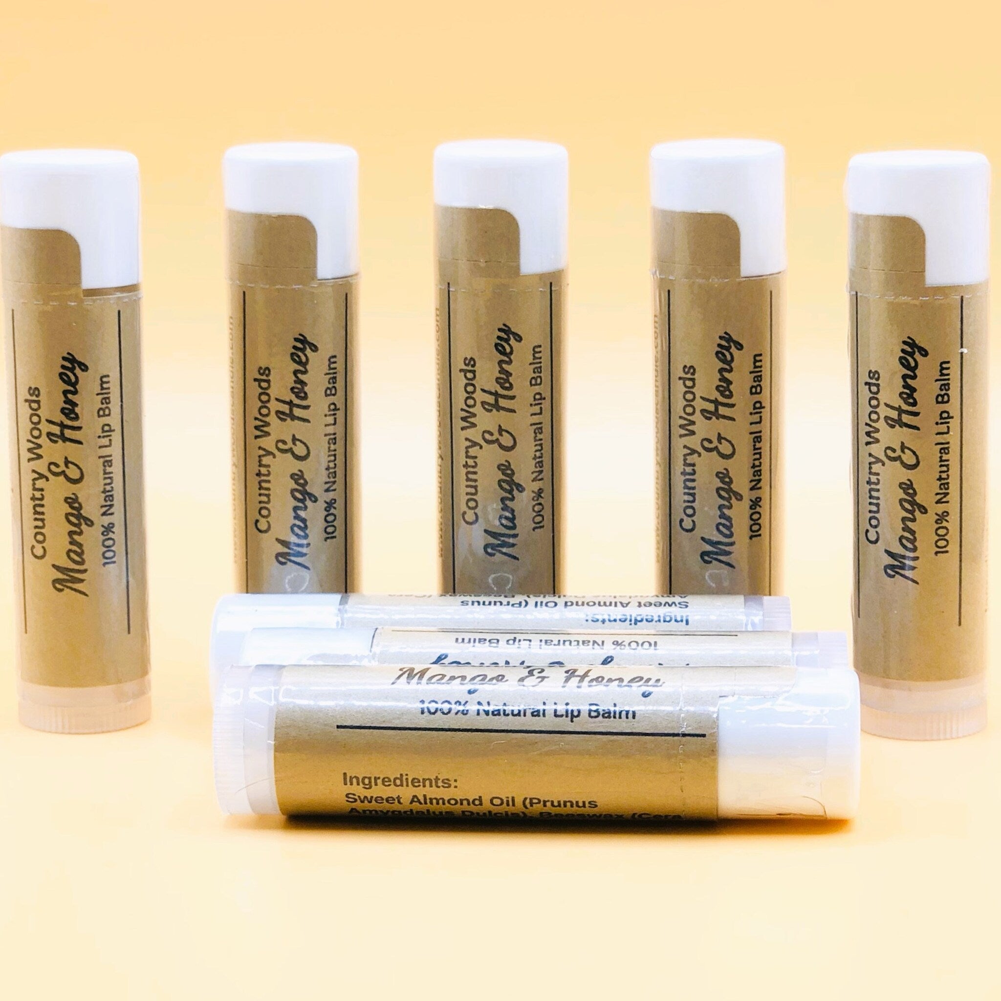 Lip balm tubes with white and brown packaging, Country Woods Mango & Honey label visible