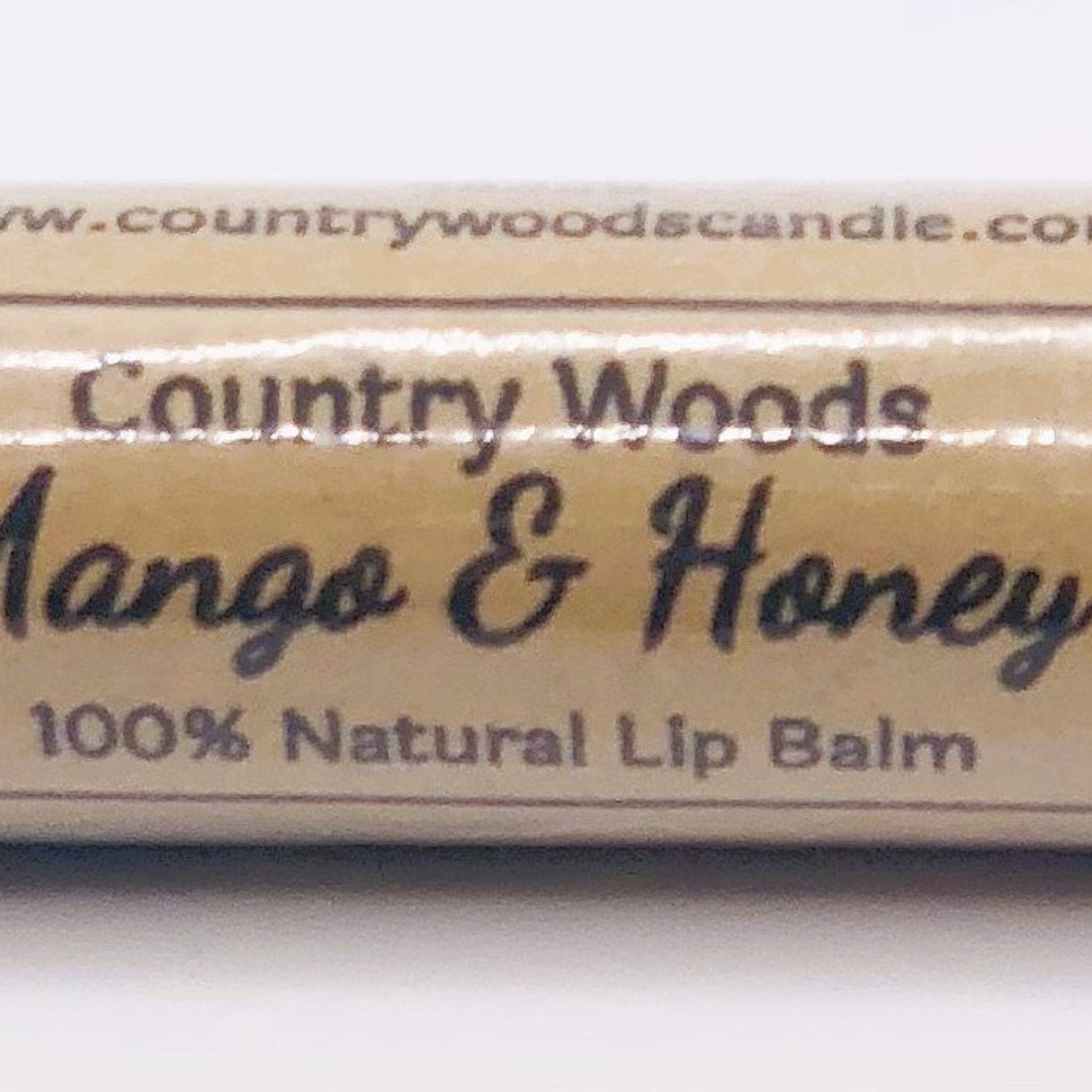 Lip balm product with tan background, black text, and Country Woods brand name visible