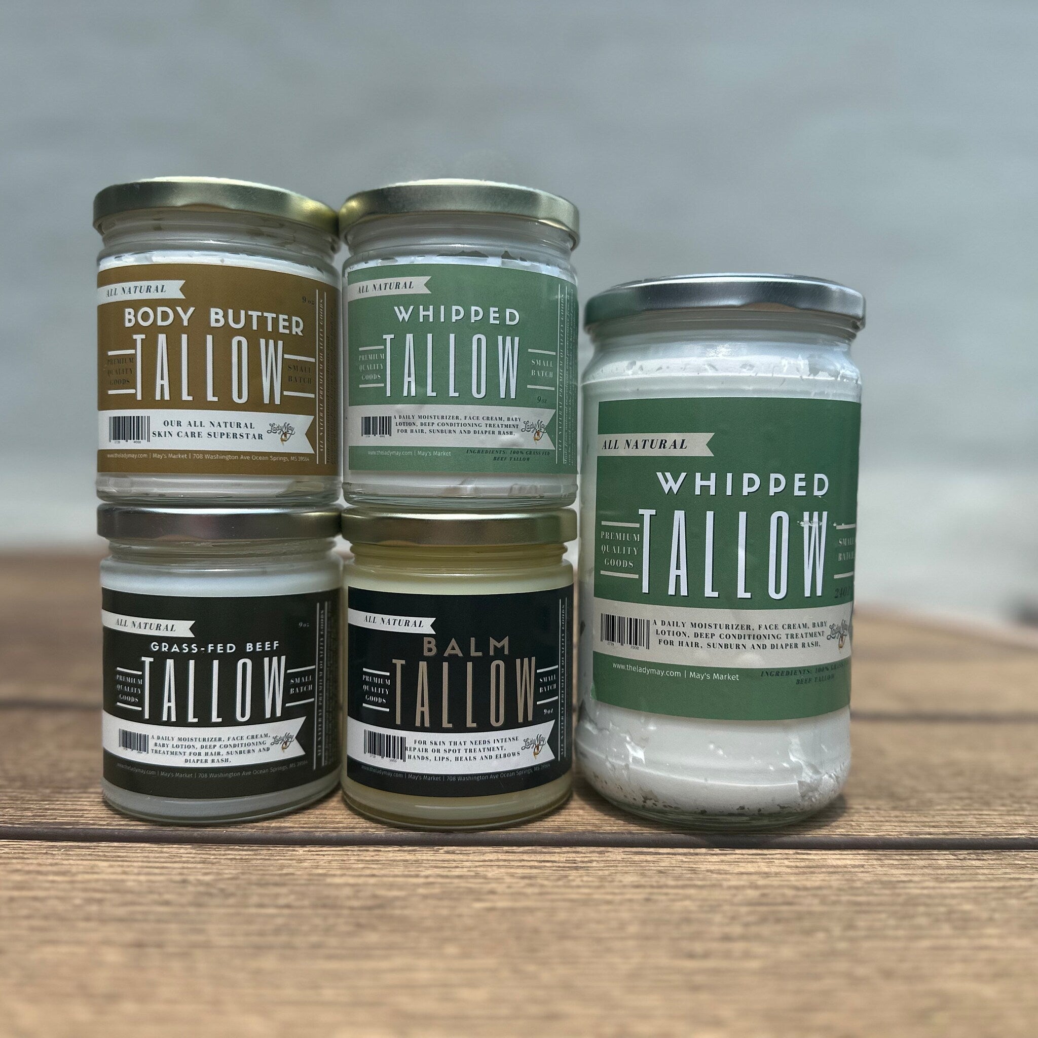 Tallow jars with white, green, and brown labels, Lady May brand visible, on wooden surface