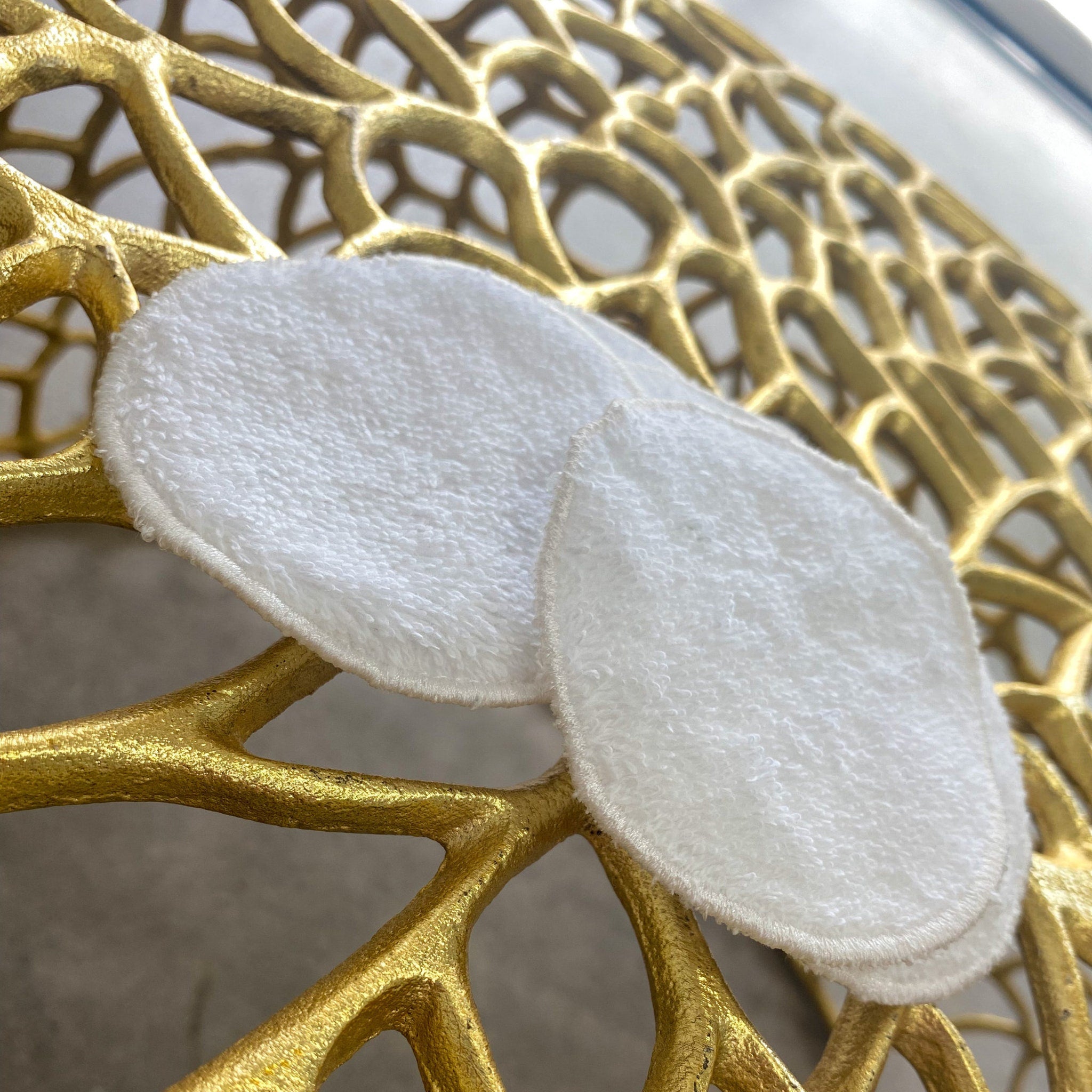 Reusable facial pads, white terry cloth, round shape on gold decorative surface