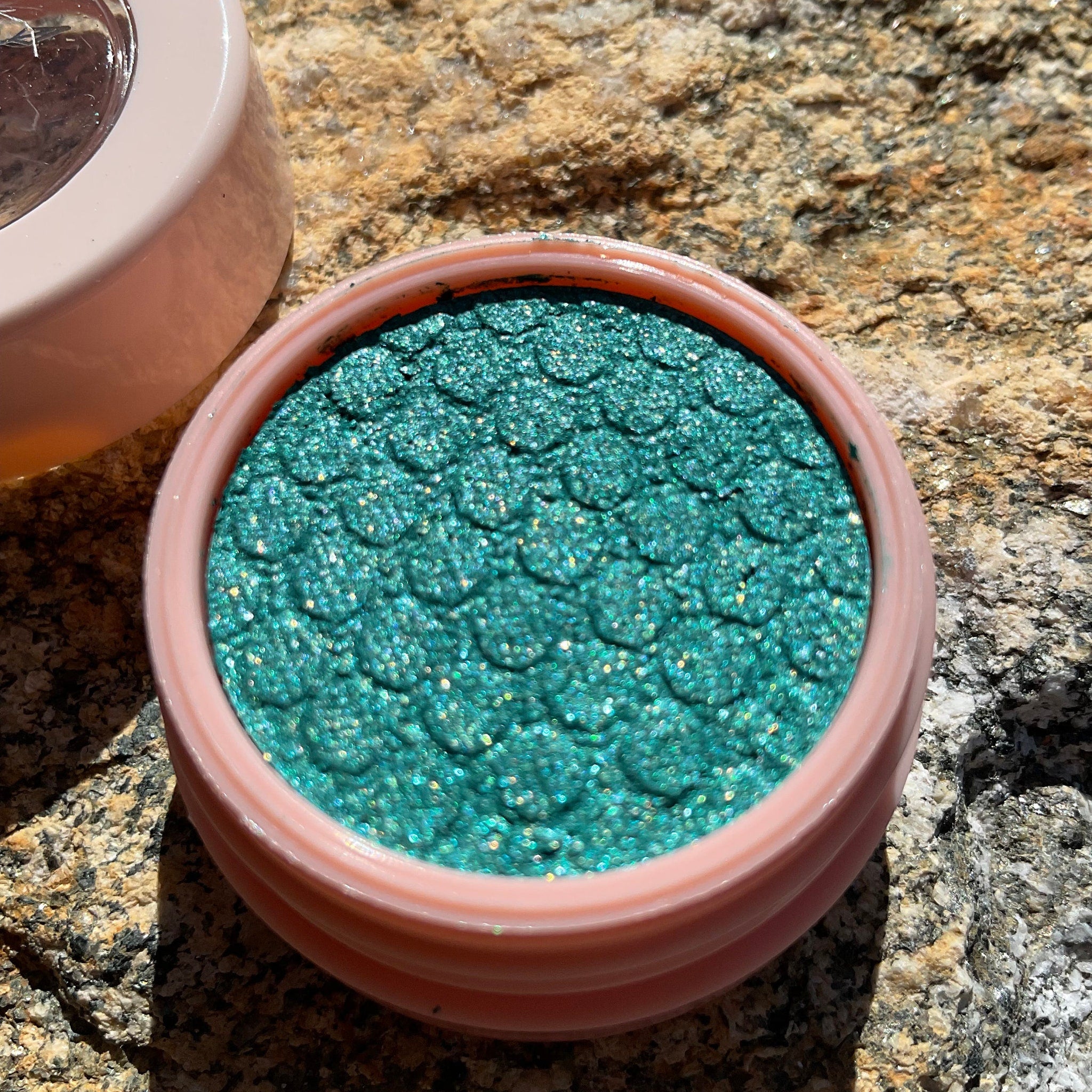 Side view of ColourPop Merida Super Shock Eye Shadow pot showing emerald green shade and Disney princess branding