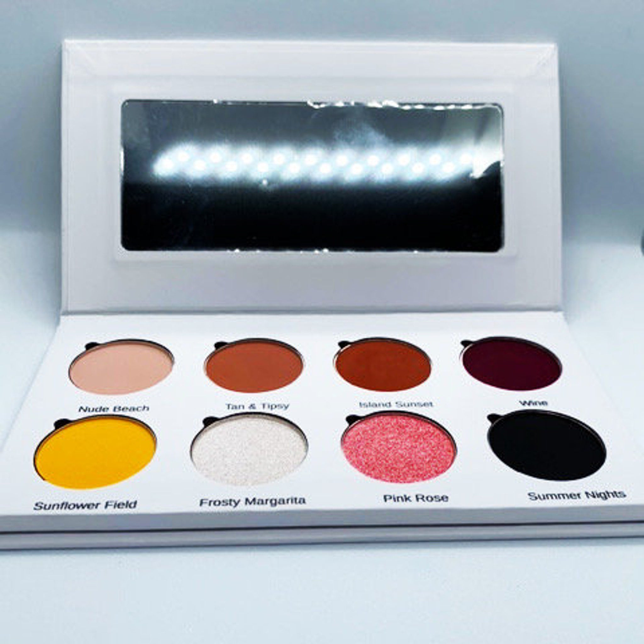 Eco-friendly cardboard palette with vibrant sunset-inspired eyeshadow shades arranged in circular pans