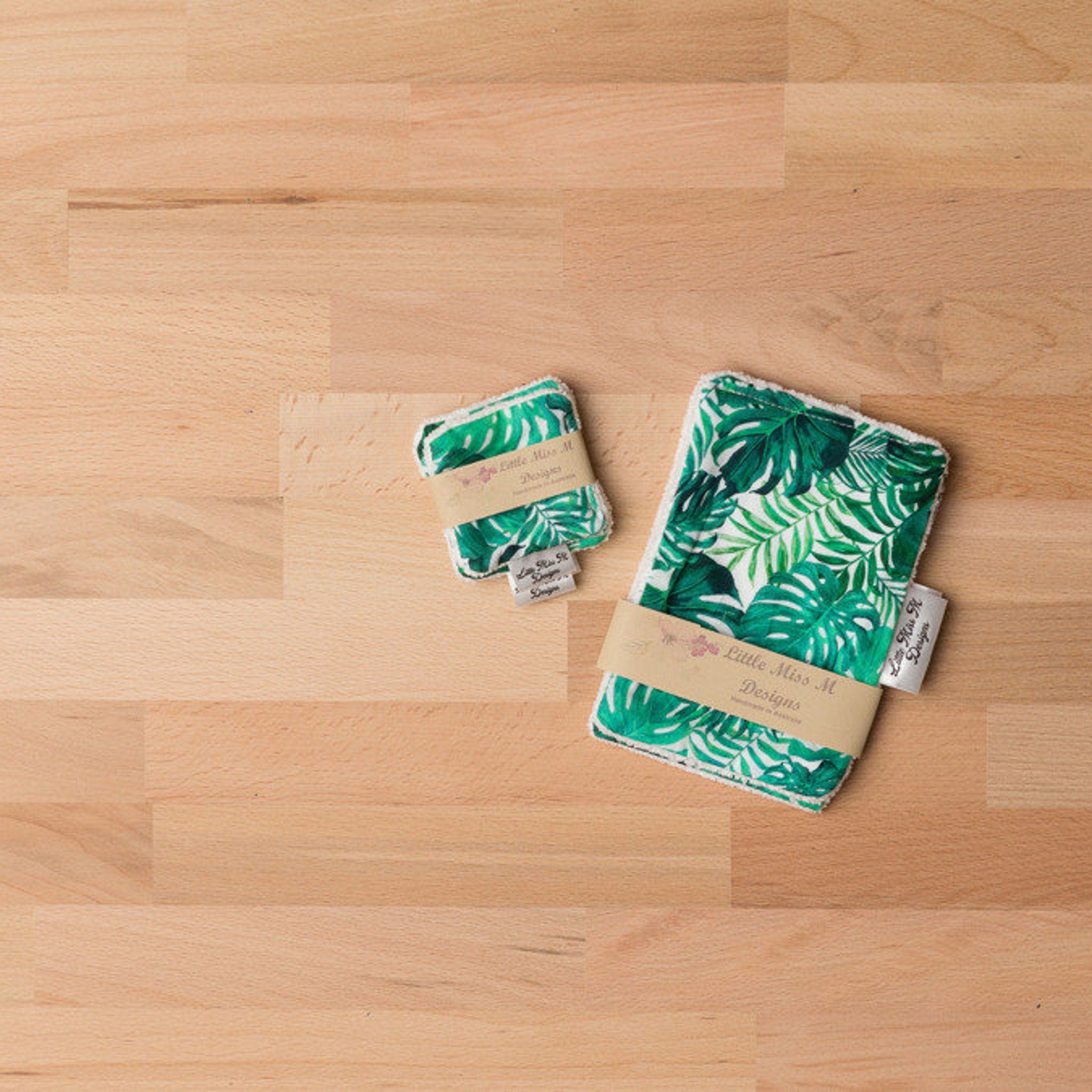 Reusable wipes with green leaf pattern and Little Miss M Designs brand label on wood surface